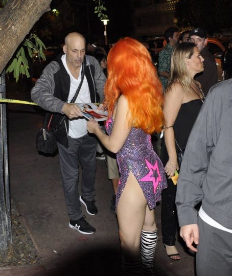 Charli XCX Wearing a orange wig and knee high zebra pattern