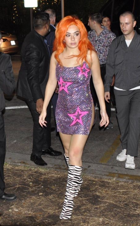 Charli XCX Wearing a orange wig and knee high zebra pattern