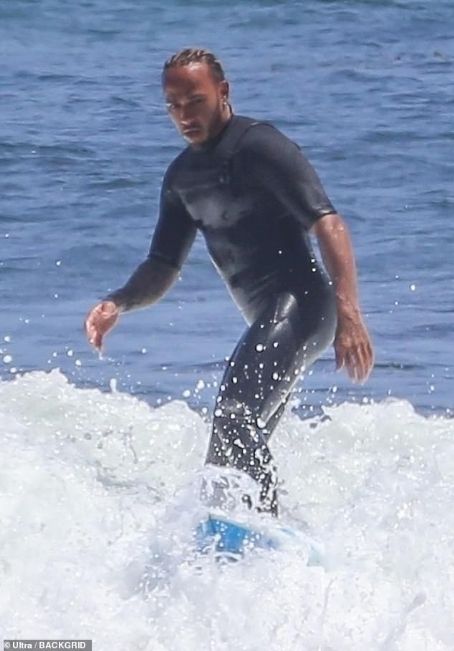Is there ANYTHING he's not good at? Lewis Hamilton dons a wetsuit as he goes surfing with pals in Malibu ahead of the British Grand Prix