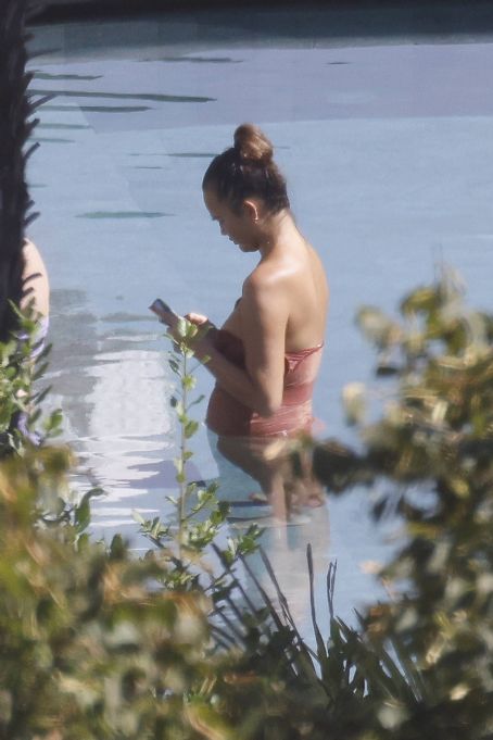 Chrissy Teigen – Seen by a swimming pool in Lake Como
