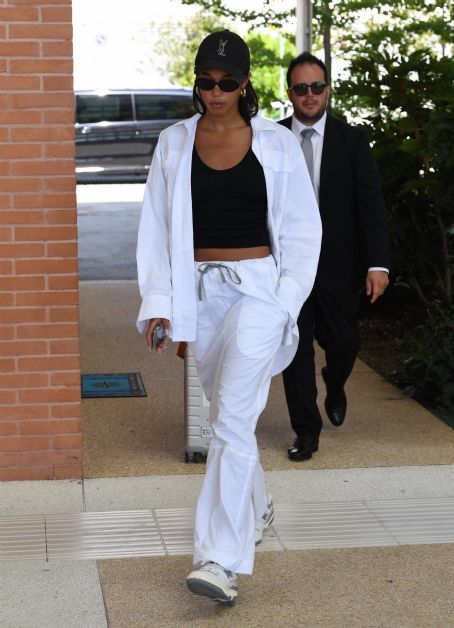 Laura Harrier – In a white tracksuit arriving at Venice Film Festival
